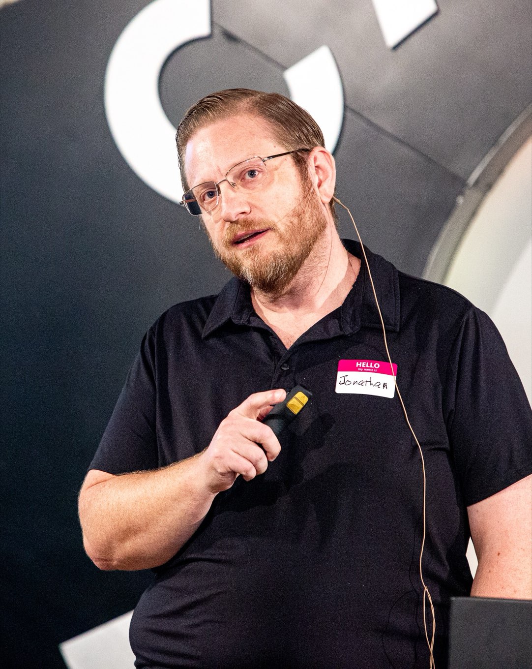 Jonathan Malkin speaking to a room, holding a presentation clicker.